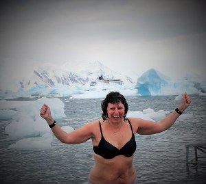 Kristin kommer opp av vannet med hendene over hodet