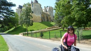 Kristin på sykkel i forgrunnen med slott i bakgrunnen.