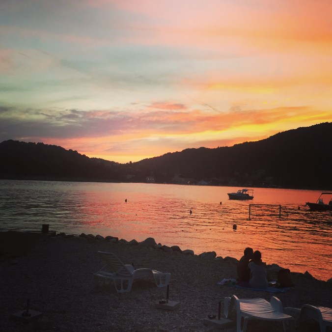 solnedgang rød solnedgang med et par som kysser i siluett.