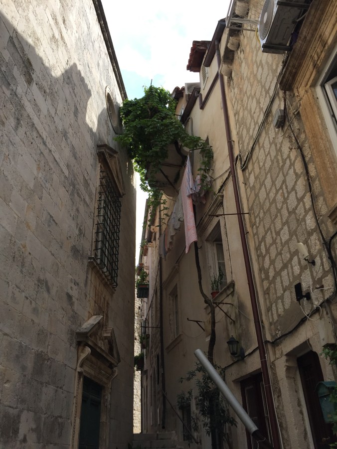 bor folk gamle murer og en klesnor med håndklær på.