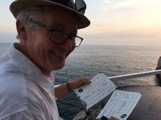 i kveldslys Mann med hatt ser inn i kamera og smiler.